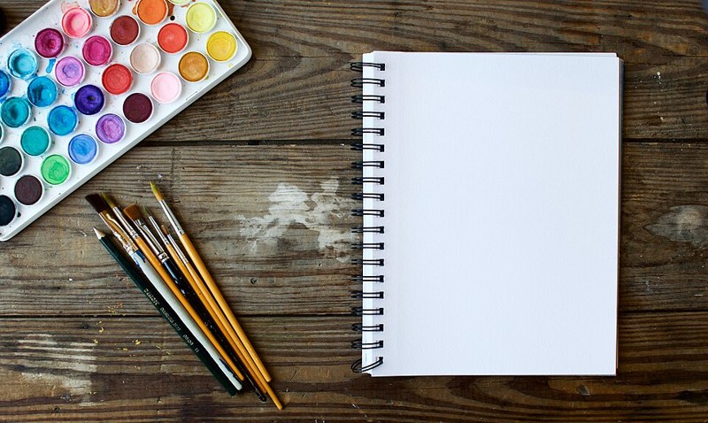 Photograph of watercolour palette and sketchbook.