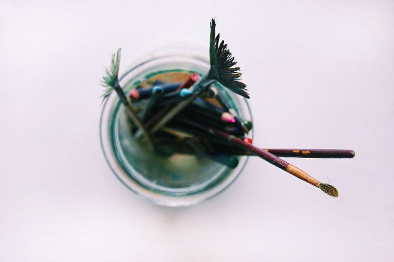 Photograph of jar of paintbrushes.