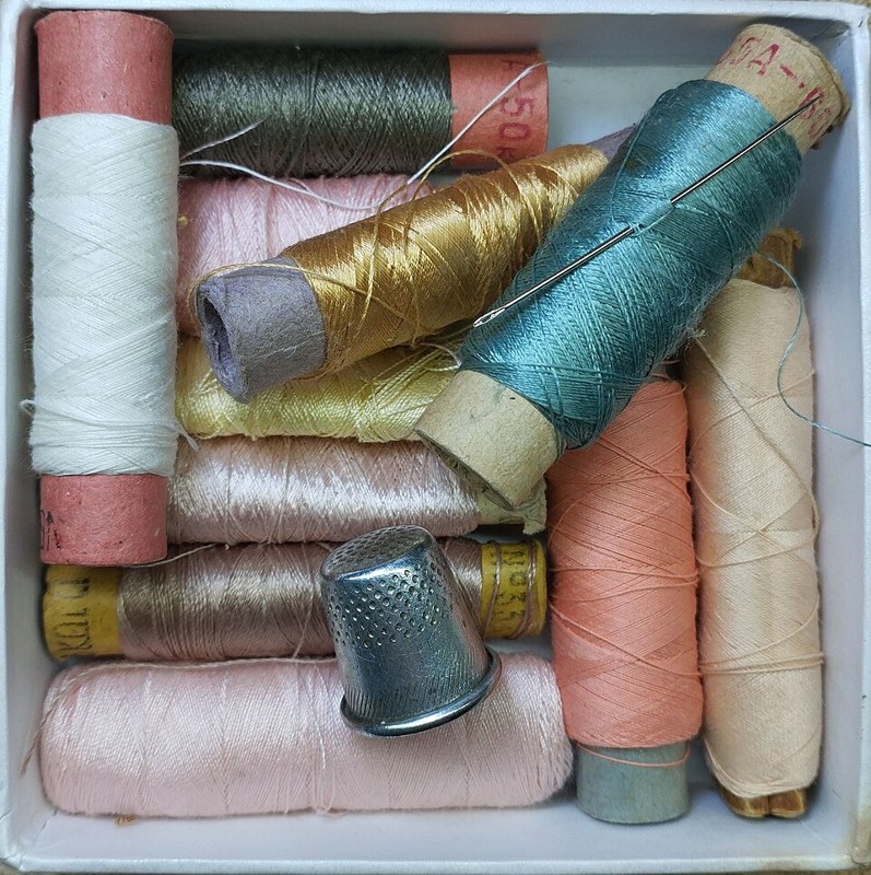 Photograph of threads and thimble.