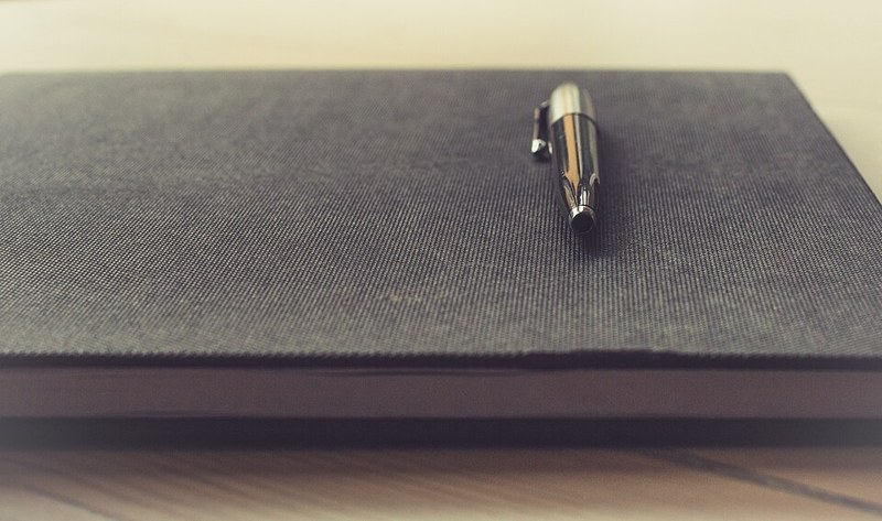 Photograph of notebook and pen.